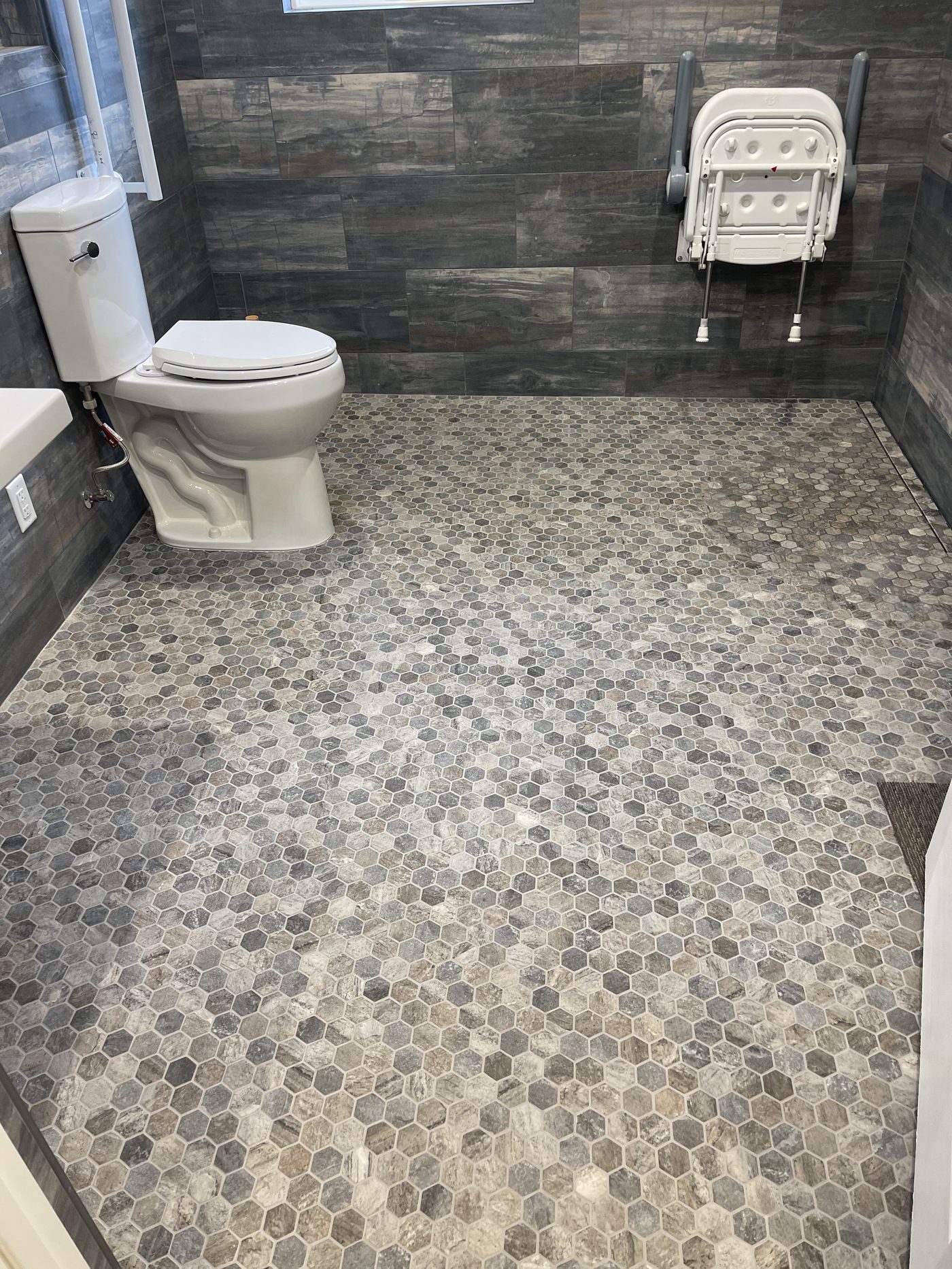 Accessible bathroom remodel with curbless walk-in shower and grab bars in Monterey County